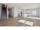 Open-concept living area with wood floors, staircase, and modern kitchen with white cabinetry at 19088 E 94Th Pl, Commerce City, CO 80022