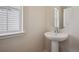 Bright powder room with modern fixtures, vanity sink, large mirror, and natural light at 19088 E 94Th Pl, Commerce City, CO 80022