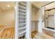 Well-organized closet featuring built-in shelving, hanging rods, and hardwood floors, next to glass shower at 5396 Bear Mountain, Evergreen, CO 80439