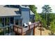 Lovely blue home with an elevated deck featuring outdoor seating and beautiful wood railing at 5396 Bear Mountain, Evergreen, CO 80439