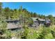 Scenic exterior of a grey house nestled among lush trees, offering privacy and a connection with nature at 5396 Bear Mountain, Evergreen, CO 80439