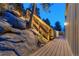 Exterior view of lighted steps and walkway surrounded by large rock formations at night at 5396 Bear Mountain, Evergreen, CO 80439