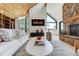 Inviting living room featuring a stone fireplace, wood ceiling, and large windows for ample natural light at 5396 Bear Mountain, Evergreen, CO 80439