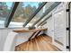 Cozy sunroom with a custom wood desk, hardwood floors, and skylight at 5396 Bear Mountain, Evergreen, CO 80439