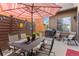 Charming back patio with a dining set, stylish umbrella, and a string of patio lights at 2429 S Orchard St, Lakewood, CO 80228