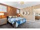 Primary bedroom features a wood accent wall, ensuite bath, and plush carpet at 2429 S Orchard St, Lakewood, CO 80228