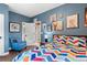 A blue bedroom with a colorful comforter, a door to a closet, and decorations at 2429 S Orchard St, Lakewood, CO 80228