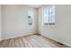 Bright bedroom featuring two windows and elegant wood-look flooring at 14400 Heritage Dr, Mead, CO 80504