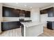 Contemporary kitchen with dark cabinetry, an island, and bright, white countertops at 14400 Heritage Dr, Mead, CO 80504