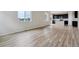 Bright living room featuring wood-look flooring and windows, adjacent to the kitchen at 14400 Heritage Dr, Mead, CO 80504