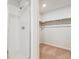 Bright shower stall with glass door and white tile, adjacent to walk-in closet with shelving at 14400 Heritage Dr, Mead, CO 80504