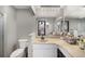 Bright bathroom featuring a vanity with white cabinets and neutral counters, and a door to the Primary bedroom at 7371 Otis Ct, Arvada, CO 80003