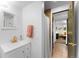 Well-lit bathroom with a modern vanity, decorative mirror, and convenient access to the living area at 7371 Otis Ct, Arvada, CO 80003