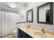 Updated bathroom with double vanity, custom mirrors, subway tile shower, and neutral color scheme at 7371 Otis Ct, Arvada, CO 80003