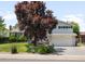 Charming two-story home with a well-manicured lawn, mature trees, and a two-car garage at 7371 Otis Ct, Arvada, CO 80003
