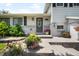 Charming front door with a wreath and well-manicured landscaping featuring colorful flowers and lush greenery at 7371 Otis Ct, Arvada, CO 80003