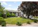 Well-maintained front yard with lush green lawn, mature trees, and colorful flower beds enhancing curb appeal at 7371 Otis Ct, Arvada, CO 80003
