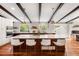 Modern kitchen with stainless steel appliances, a spacious island with seating, and beautiful hardwood floors at 7371 Otis Ct, Arvada, CO 80003