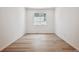 Bright, minimalist bedroom with neutral hardwood floors and a large window for natural light at 9091 Telluride Ct, Commerce City, CO 80022