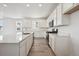 Stylish kitchen with white cabinets, quartz countertops, stainless steel appliances and wood-look flooring at 9091 Telluride Ct, Commerce City, CO 80022