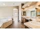Primary bathroom with a soaking tub, double sink vanity, and neutral tile at 1905 Graphite Ct, Castle Rock, CO 80108