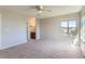 Spacious bedroom with neutral walls, carpet flooring, ceiling fan, and large window providing natural light at 1905 Graphite Ct, Castle Rock, CO 80108