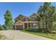 Two-story home with a three car garage, covered porch, manicured lawn and mature landscaping at 1905 Graphite Ct, Castle Rock, CO 80108