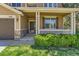 Inviting front porch showcasing stone accents, a charming wood door, and manicured shrubbery at 1905 Graphite Ct, Castle Rock, CO 80108