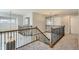 An open hallway features wood and wrought iron railings, neutral colors, and elegant light fixtures at 1905 Graphite Ct, Castle Rock, CO 80108