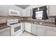 White appliances and gray cabinets in kitchen at 5341 W 76Th Ave # 221, Arvada, CO 80003