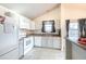 Galley kitchen with white appliances and gray cabinets at 5341 W 76Th Ave # 221, Arvada, CO 80003