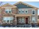 Two-story townhome with stone and siding exterior, inviting front porch, and attached garage at 1126 S Yampa St, Aurora, CO 80017