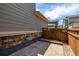 Cozy outdoor patio area with stone accents and a wooden fence, perfect for relaxing or entertaining at 1126 S Yampa St, Aurora, CO 80017