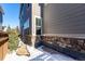 Side yard with stone wall, wooden fence, and small patio area at 1126 S Yampa St, Aurora, CO 80017