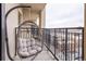 Balcony seating with city views, wrought iron railings, and a comfortable hanging egg chair at 975 N Lincoln St # 10A, Denver, CO 80203