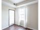 The bedroom is bright with a window featuring white sheer curtains, hardwood floors and neutral-painted walls at 975 N Lincoln St # 10A, Denver, CO 80203