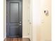 Hallway view featuring a dark wood door, a thermostat and a light switch at 975 N Lincoln St # 10A, Denver, CO 80203