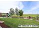 Lush green backyard with a playset and a view of the open fields beyond the fence at 16333 Prairie Farm Cir, Parker, CO 80134