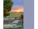A picturesque backyard scene at sunset, featuring a stone pathway, and a cornhole game at 16333 Prairie Farm Cir, Parker, CO 80134