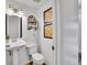 Neat half bathroom with a pedestal sink, stylish light fixture, and decorative artwork at 4670 E Euclid Cir, Centennial, CO 80121