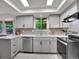 Modern kitchen with gray cabinets, stainless steel appliances, stone backsplash, and quartz countertops at 4670 E Euclid Cir, Centennial, CO 80121