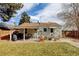 Beautiful backyard with a covered patio dining area, fire pit, and lush green lawn for outdoor enjoyment at 4509 Eliot St, Denver, CO 80211