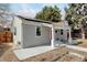 Side view of home with red door, solar panels, and covered porch featuring white columns and concrete walkway at 4509 Eliot St, Denver, CO 80211