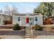 Charming single-story home featuring a red front door, solar panels, and landscaped front yard with retaining wall at 4509 Eliot St, Denver, CO 80211