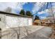 View of a detached two-car garage with a large driveway and newly stained horizontal plank fence at 4509 Eliot St, Denver, CO 80211