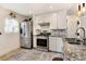 Bright kitchen featuring stainless steel appliances, white cabinets, granite countertops, and stone tile floor at 4509 Eliot St, Denver, CO 80211