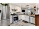 Modern kitchen features stainless steel appliances, white cabinets, granite countertops, and decorative backsplash at 4509 Eliot St, Denver, CO 80211