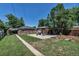 Picturesque backyard with a covered patio, lush lawn, planting beds, and an open view at 3550 Magnolia St, Denver, CO 80207