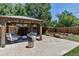 Serene backyard showcasing a covered patio, fire pit, manicured lawn, and planting beds at 3550 Magnolia St, Denver, CO 80207