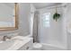 Updated bathroom features a vanity with marble countertop, tiled shower with curtain, and hanging plant at 3550 Magnolia St, Denver, CO 80207